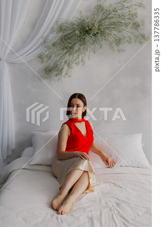 Young beautiful woman posing on a luxurious bed Young beautiful woman posing on a luxurious bed 137786335