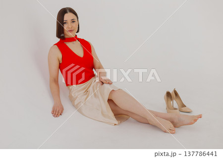 Young beautiful woman posing near white wall 137786441