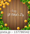 Happy St. Patrick's Day with clover leaves and gold coins above wooden background 137786542