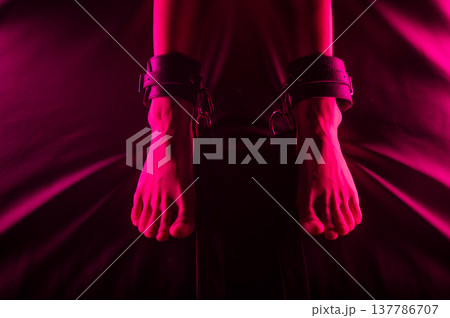 Women's legs in leather shackles. BDSM fetish. 137786707