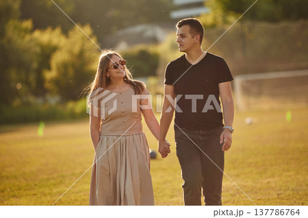 Couple have a walk on the summer field Couple have a walk on the summer field 137786764