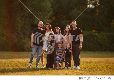 Looking forward. Family with adults and kids is standing on the field Looking forward. Family with adults and kids is standing on the field 137786850