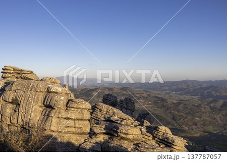 View of stone formations at El Torcal in Spain during sunset showing the landscape and mountains in the distance 137787057