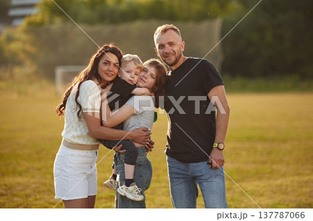 Green field, summertime. Photo of happy family with husband, wife and two kids 137787066