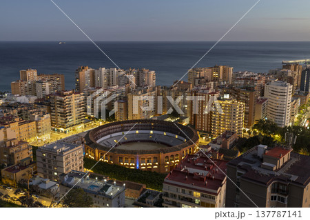 City view of Malaga Spain with the bullring at sunset near the coast and tall buildings in the background City view of Malaga Spain with the bullring at sunset near the coast and tall buildings in the background 137787141