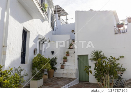 Exploring the narrow streets and white buildings of Frigiliana in southern Spain on a sunny day 137787163