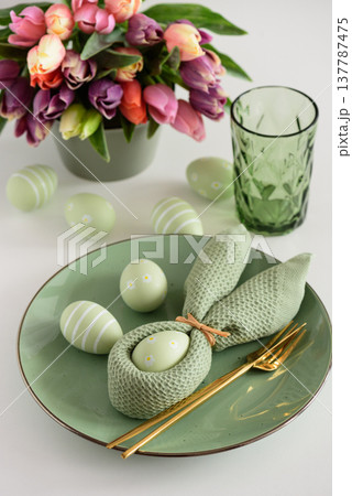 Easter Table Setting with Bunny Napkin, Decorated Eggs and Colorful Tulips. Festive Spring Arrangement 137787475