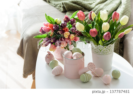 Easter Table with Tulip Bouquets, Eggs and Festive Decor. Cozy Spring Arrangement Easter Table with Tulip Bouquets, Eggs and Festive Decor. Cozy Spring Arrangement 137787481