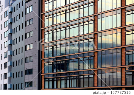 景色を映し出す窓ガラスが美しいビル 137787516