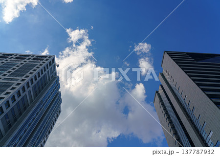 Tokyo, Japan - Oct 13 2024, panoramic view of the blue cloudy sky between the facades of two skyscrapers, at daytime, Tokyo, Japan 137787932
