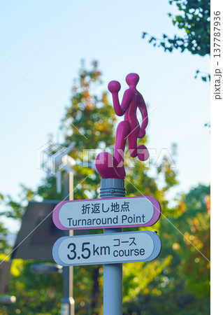 Tokyo, Japan - Oct 13 2024, vertical, a close-up view of a sign decorated with a running man figurine with inscription Turnaround Point on bottom, in the background a trees in park, Tokyo, Japan Tokyo, Japan - Oct 13 2024, vertical, a close-up view of a sign decorated with a running man figurine with inscription Turnaround Point on bottom, in the background a trees in park, Tokyo, Japan 137787936