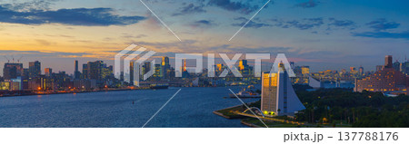 Tokyo, Japan - Oct 2 2024, panoramic aerial view of Tokyo Bay cityscape in background and the Rainbow Bridge, in the foreground is a part of Odaiba Island with a triangular building, Tokyo, Japan 137788176