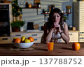Serene woman enjoying her drink while relaxing peacefully nearby, Calm and composed woman taking break with refreshing beverage and nearby fruit in peaceful surroundings 137788752