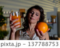 Woman inspects beverage, Woman evaluates drink quality accurately, Individual carefully checks freshness of juice, Person assesses quality and freshness of beverage at home 137788753