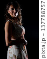 Stylish woman stands confidently with artistic lighting and warm hues, Graceful female figure exhibits calm confidence under artistic backlight in studio setting 137788757