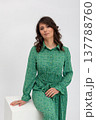 Elegant confident lady, Fashionable woman showcases style, Relaxed woman with curly hair exudes confidence, Stylish individual leaning on cube with calm demeanor and natural pose 137788760