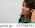 Thoughtful female viewed from side, Contemplative woman in profile against plain background, Woman wearing green is captured in contemplative profile with simple backdrop 137788761
