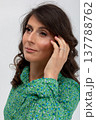 Poised woman glowing softly, Refined female with gentle lighting and pleasant smile, Sophisticated lady dressed in green radiating calm confidence with slight smile 137788762