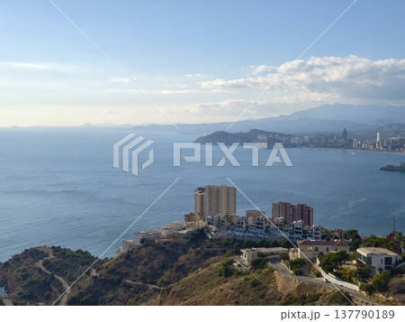 Sunlit Ocean And Distant City, Scenic Coastal Scene With City In Background And Rocky Foreground Sunlit Ocean And Distant City, Scenic Coastal Scene With City In Background And Rocky Foreground 137790189