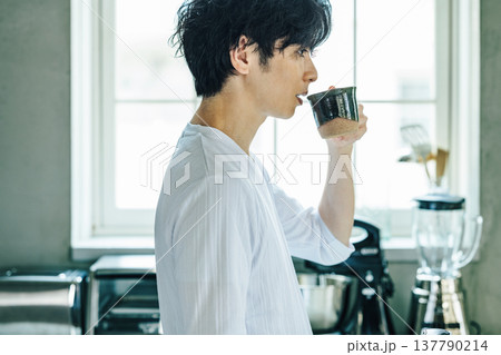 自宅でコーヒーを飲む若い男性 自宅でコーヒーを飲む若い男性 137790214