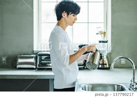 ポットでコーヒーカップにお湯を入れる男性 137790217