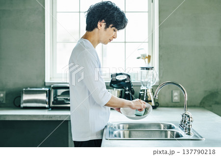 家の台所で食器を洗う若い男性 家の台所で食器を洗う若い男性 137790218