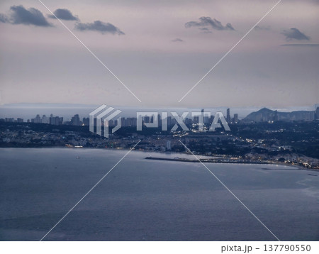 Serene Dusk With Towering Silhouettes, Calm Water Reflects Mountains And City Lights Harmoniously Serene Dusk With Towering Silhouettes, Calm Water Reflects Mountains And City Lights Harmoniously 137790550
