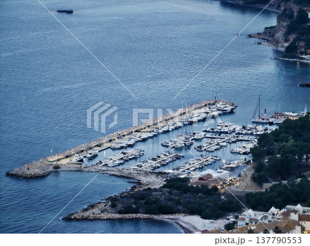 Calm Harbor With Docked Yachts, Tranquil Port Featuring Lined Vessels And Protective Seawalls 137790553