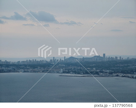 Dusk Water Scenery, Peaceful Seascape During Evening With Distant Urban Lights And Gently Rolling Water 137790568