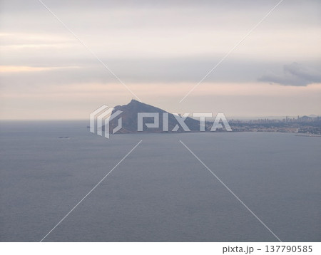 Serene Distant Land Under Tranquil Sky, Quiet Promontory Beside Expansive Calm Waters With Muted Sky Tone Serene Distant Land Under Tranquil Sky, Quiet Promontory Beside Expansive Calm Waters With Muted Sky Tone 137790585