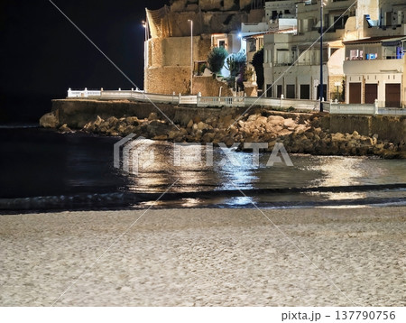 Serene Night Coast, Tranquil Beach Under Moonlight With Shimmering Reflections From Nearby Structures Serene Night Coast, Tranquil Beach Under Moonlight With Shimmering Reflections From Nearby Structures 137790756