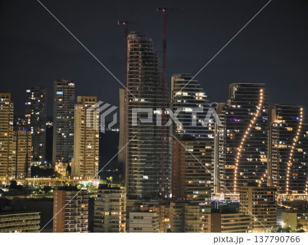 Bright Skyscrapers And City Lighting, Modern Buildings Silhouette With Vibrant Urban Atmosphere 137790766