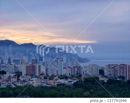 City Evening Panorama, Sunset Over Mountain Cityscape, Calm City Skyline With Glowing Waterfront Buildings 137791046