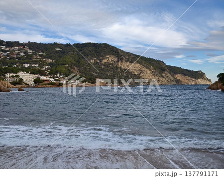 Serene Seaside With Clouded Sky, Waves Crash Against Rocky Coast While Clouds Drift Overhead Peacefully 137791171