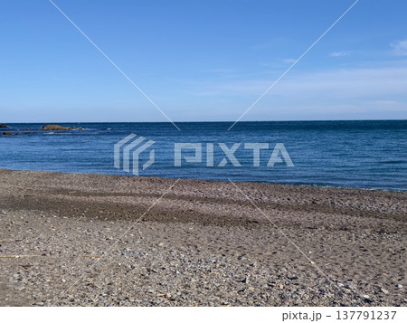 Pebble Beach With Calm Blue Sea, Gentle Waves, Clear Sky, Empty Shoreline, Morning Light Pebble Beach With Calm Blue Sea, Gentle Waves, Clear Sky, Empty Shoreline, Morning Light 137791237