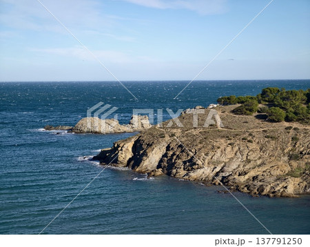 Marine Landscape Showcasing Lighthouse On Rugged Coast With Breaking Waves And Sunlit Rocky Outcrop 137791250