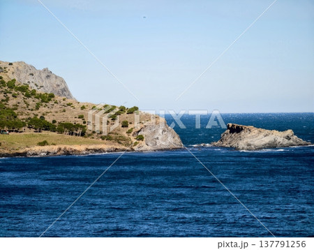 Serene Inlet Surrounded By Rugged Rocks, Tranquil Waterway Framed By Cliffs Leading To Ocean 137791256