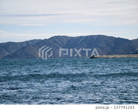 Waves Crash Beneath Distant Mountains, Vast Ocean Landscape With Shifting Teal Waters And Mountains 137791283