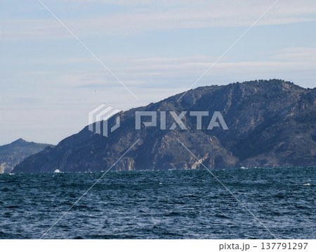 Dramatic Coastal Landscape Scene, Rugged Hillside Emerging From Frothy Water With Textured Cliffs 137791297