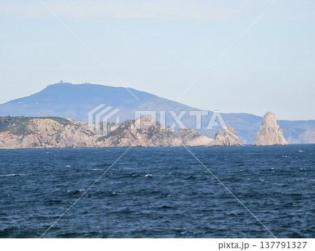 Rugged Island Above Ocean Waves, Mountainous Islet With Layered Ridges Against Vivid Ocean Backdrop 137791327