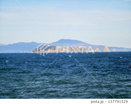 Quiet Seaside Landscape With Gentle Waves, Peaceful Island Scene Featuring Soft Sea Colors And Distant Hills Quiet Seaside Landscape With Gentle Waves, Peaceful Island Scene Featuring Soft Sea Colors And Distant Hills 137791329