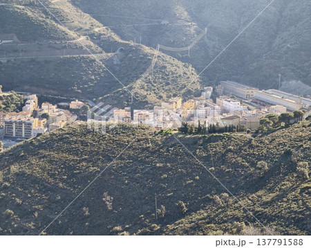 Secluded Village Nestled In Valleys, Distant Hillside Town Hidden Among Rolling Earth And Rocky Slopes Secluded Village Nestled In Valleys, Distant Hillside Town Hidden Among Rolling Earth And Rocky Slopes 137791588