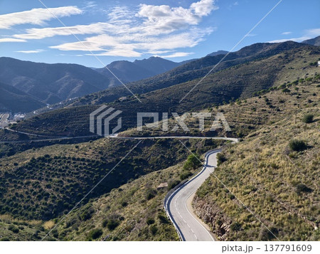 Hilly Road With Sharp Turns, Twisting Mountain Trail Cutting Across Hills With Minimal Greenery Hilly Road With Sharp Turns, Twisting Mountain Trail Cutting Across Hills With Minimal Greenery 137791609