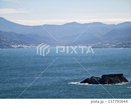 Rugged Island With Harbor View, Secluded Rocky Island With Distant Harbor And Mountain Slopes 137791644