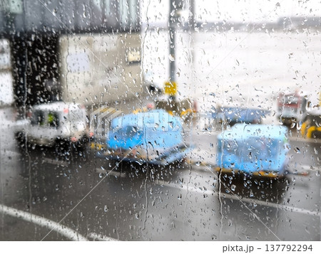 A view of the airport apron through a rain-soaked window A view of the airport apron through a rain-soaked window 137792294