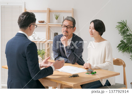 営業マンと打ち合わせをするミドル夫婦 137792914
