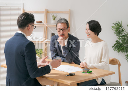 営業マンと打ち合わせをするミドル夫婦 営業マンと打ち合わせをするミドル夫婦 137792915