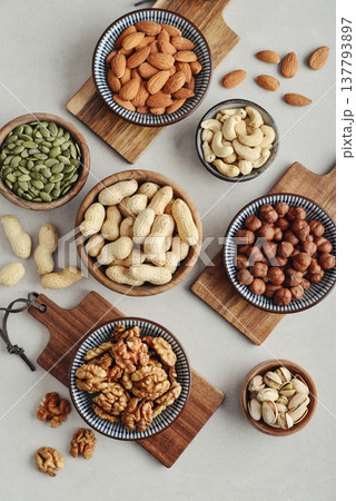 Walnuts, cashews, almonds, hazelnuts, peanuts, pistachios and pumpkin seeds in plates 137793897