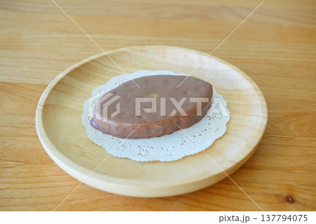木製プレートの上に置いたチョコレート菓子とレースペーパーのスイーツ写真。 木製プレートの上に置いたチョコレート菓子とレースペーパーのスイーツ写真。 137794075