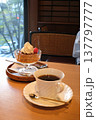 窓際の喫茶店の席でコーヒーとプリン 137797777